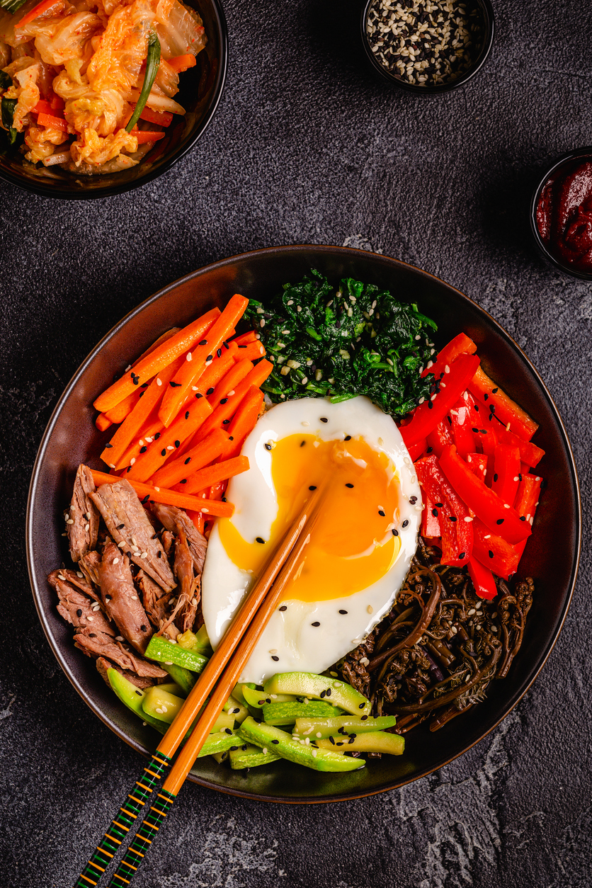 Traditional Korean dish Bibimbap: rice with vegetables beef and egg, top view.